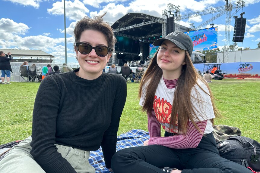 Two smiling young women at a music festival.