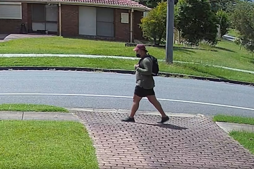 Man captured on CCTV walking outside a home.
