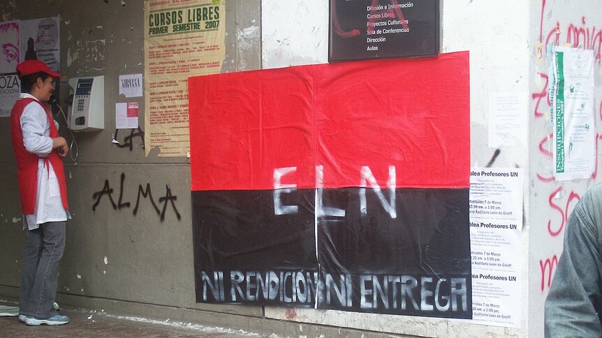 A red and black poster with ELN written in capitals stuck to a wall on a street in Columbia.