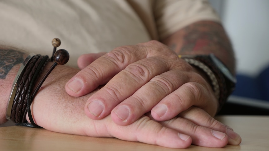 Men's hands clasped.