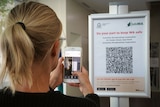 A person checks in to a venue using a QR code on a mobile phone