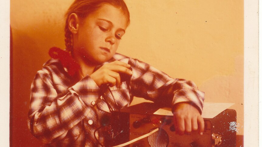 Tanya Healsipn as a child using a transistor radio while attending School of the Air in the 1960s