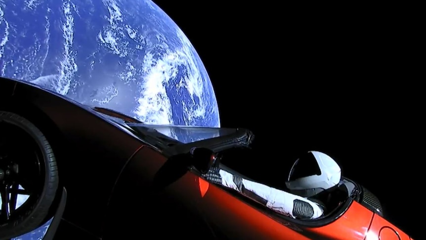 A view shows a Tesla Roadster in space.