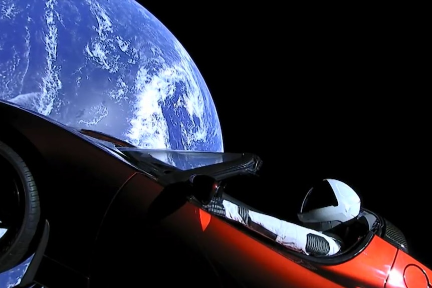 A view shows a Tesla Roadster in space.