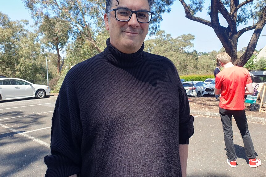 Steve Yanko smiles, standing outside a voting centre.