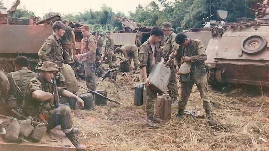Dozens of soldiers mingle and recoup surrounded by tanks, Vietnam 1971.