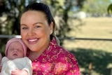 Tayla Cox wears pink and holds her baby girl Murphy