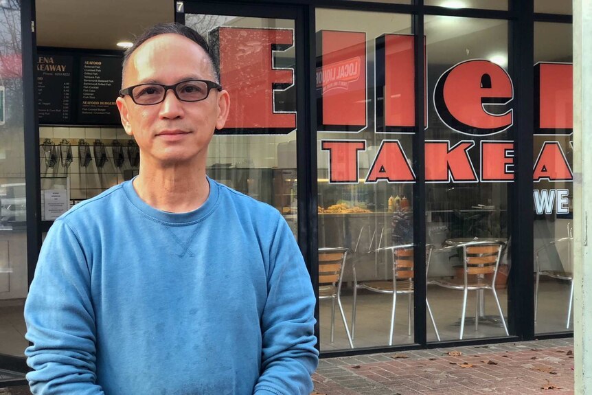 Bao Diep stands outside his store.