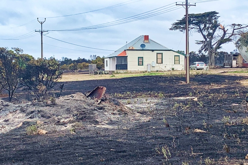 scorched ground in front of an undamaged house