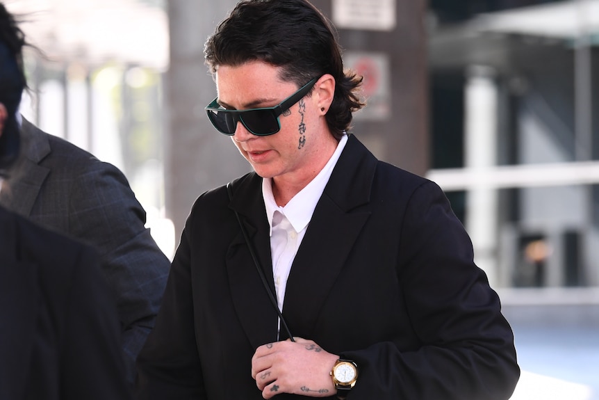A woman with a face tattoo leaving court.