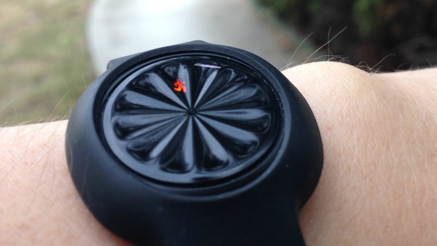 A close up of a fitness tracker on someone's wrist.