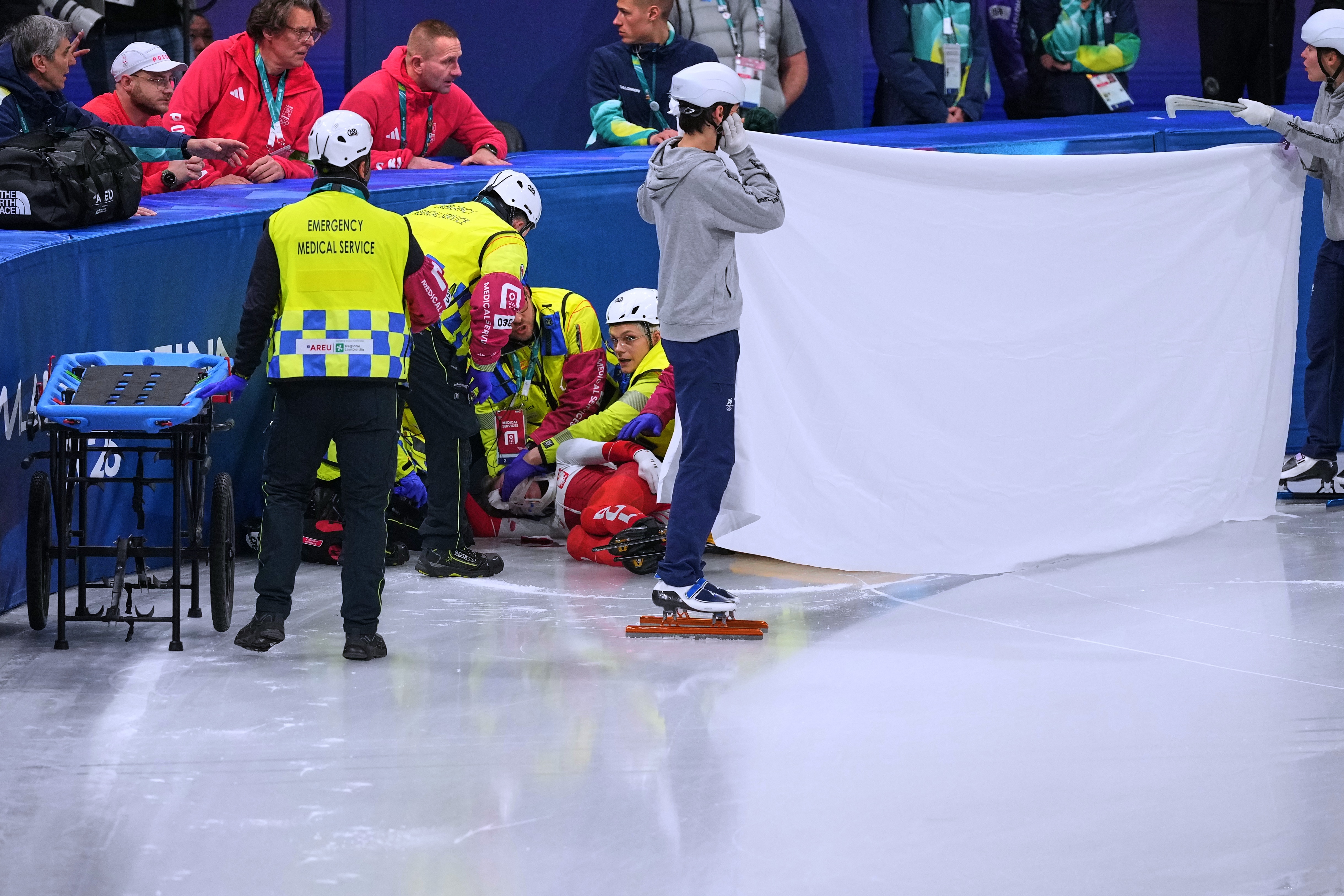 Kamila Sellier recebe tratamento após sofrer um corte no rosto durante uma corrida de patinação de velocidade em pista curta nas Olimpíadas de Inverno.