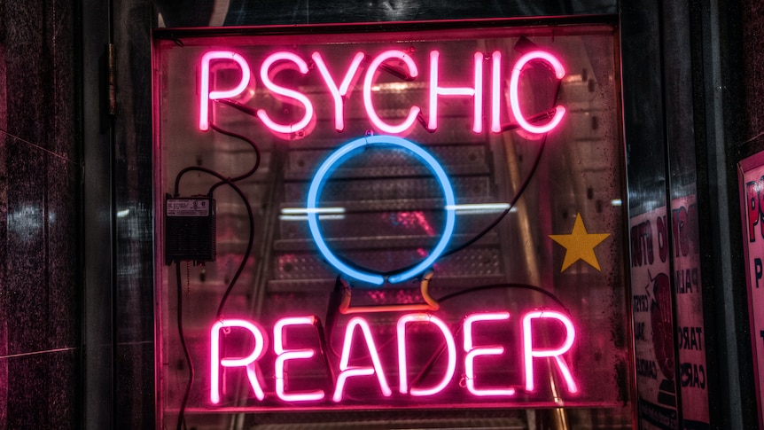 A neon sign showing the words Psychic in light blue and Tarot Card in purple.