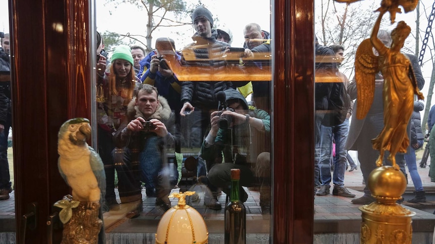 Ukrainians peer through windows of the Mezhyhirya residence of ousted president Viktor Yanukovich