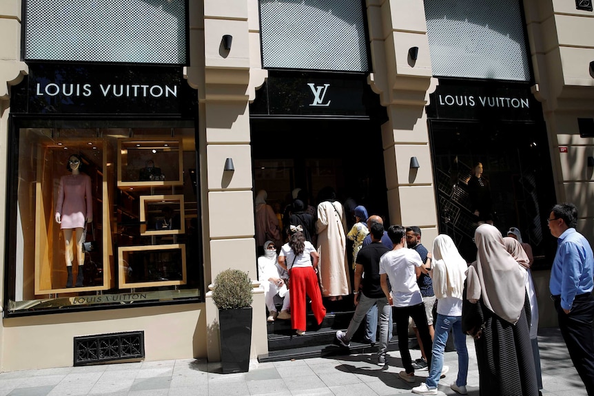FILE--Pedestrians walk past a Louis Vuitton (LV) store in