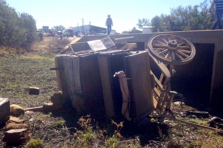 A horse-drawn stagecoach lies on its side after crashing off a bridge on the outskirts of Longreach.