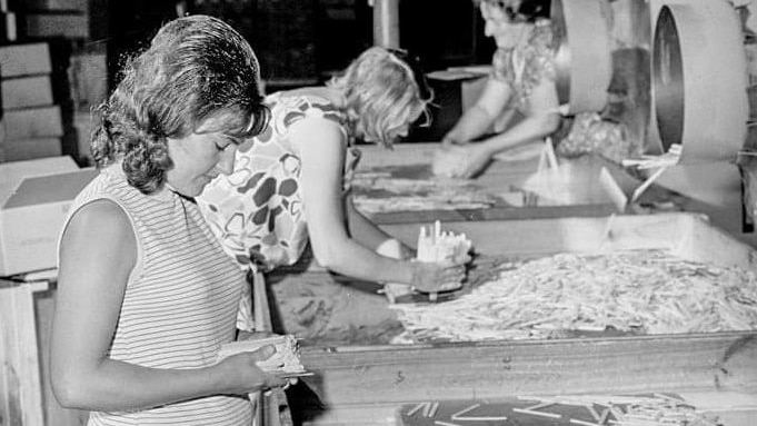 Female factory workers sorting through timber ice cream sticks