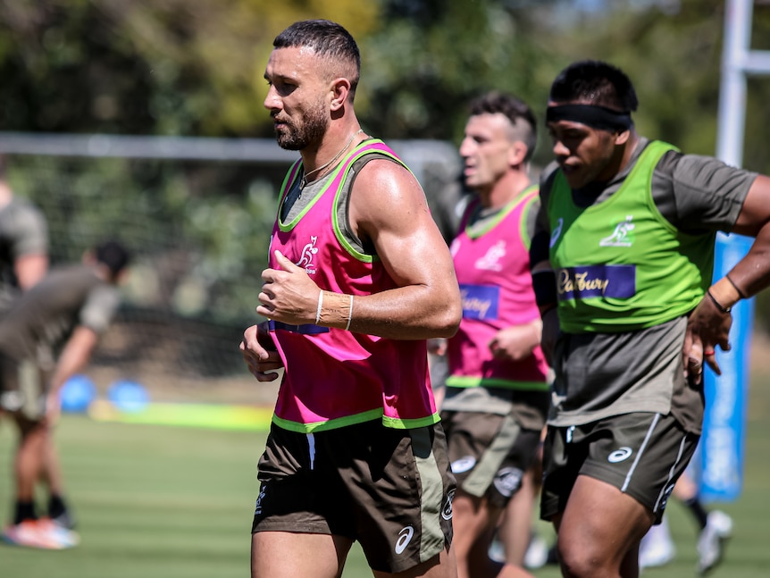 Quade Cooper wearing a training bib while running