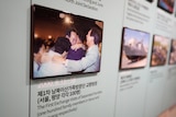 A photo displayed on a wall shows an emotional family reunion. 