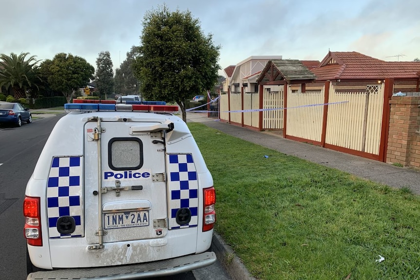 A police van is parked outside a suburban home ringed by police tape.