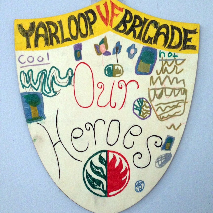 A child's hand-drawn picture of a shield which says 'Yarloop volunteer firefighter brigade, our heroes'.