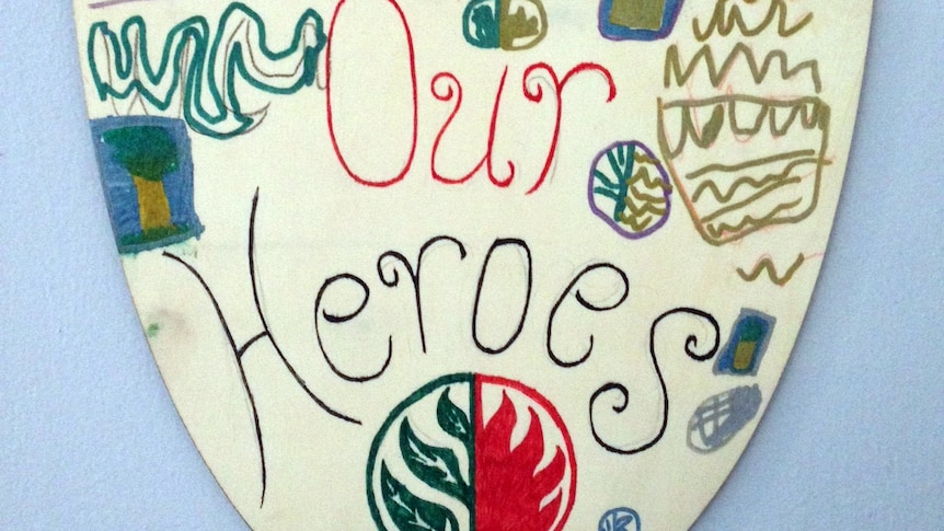 A child's hand-drawn picture of a shield which says 'Yarloop volunteer firefighter brigade, our heroes'.