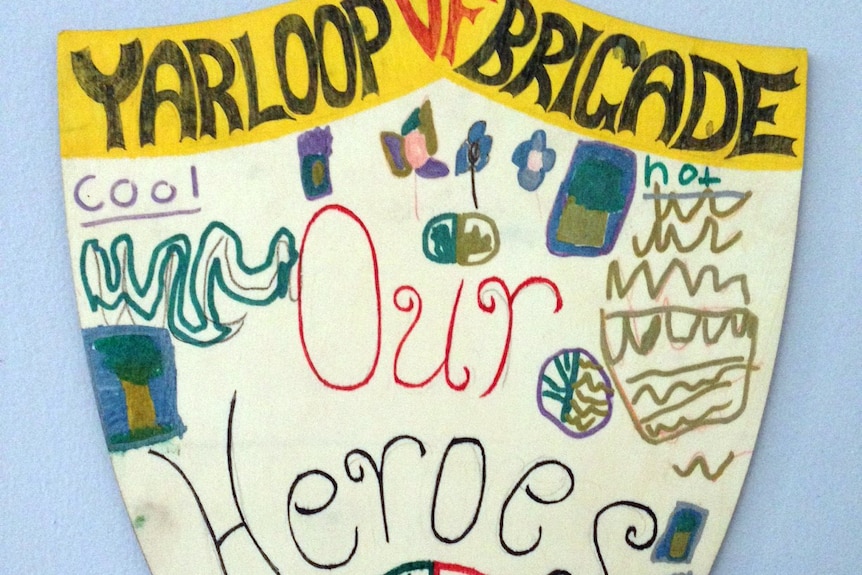 A child's hand-drawn picture of a shield which says 'Yarloop volunteer firefighter brigade, our heroes'.