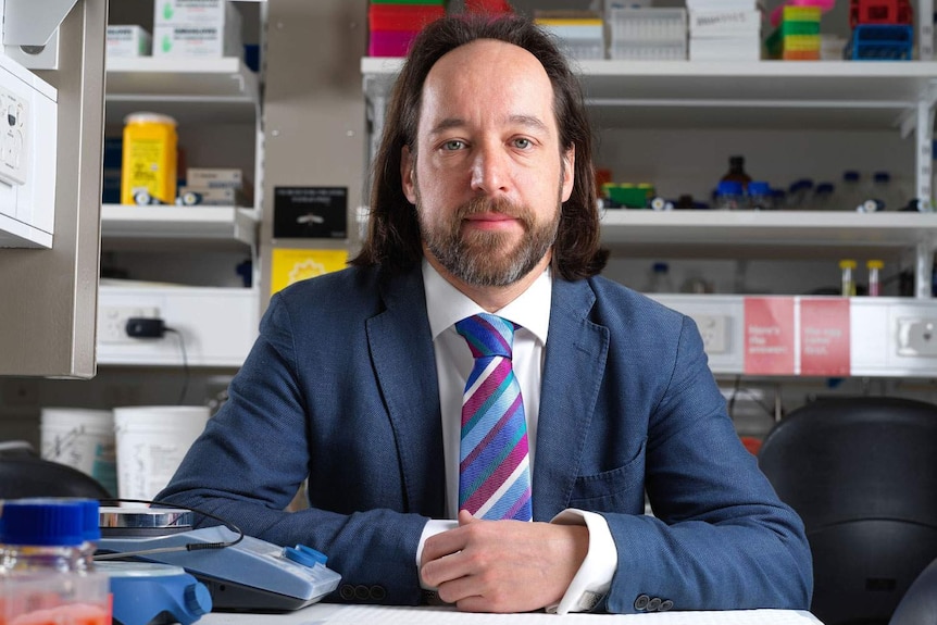 Associate Professor Stuart MacGregor sitting at a desk.