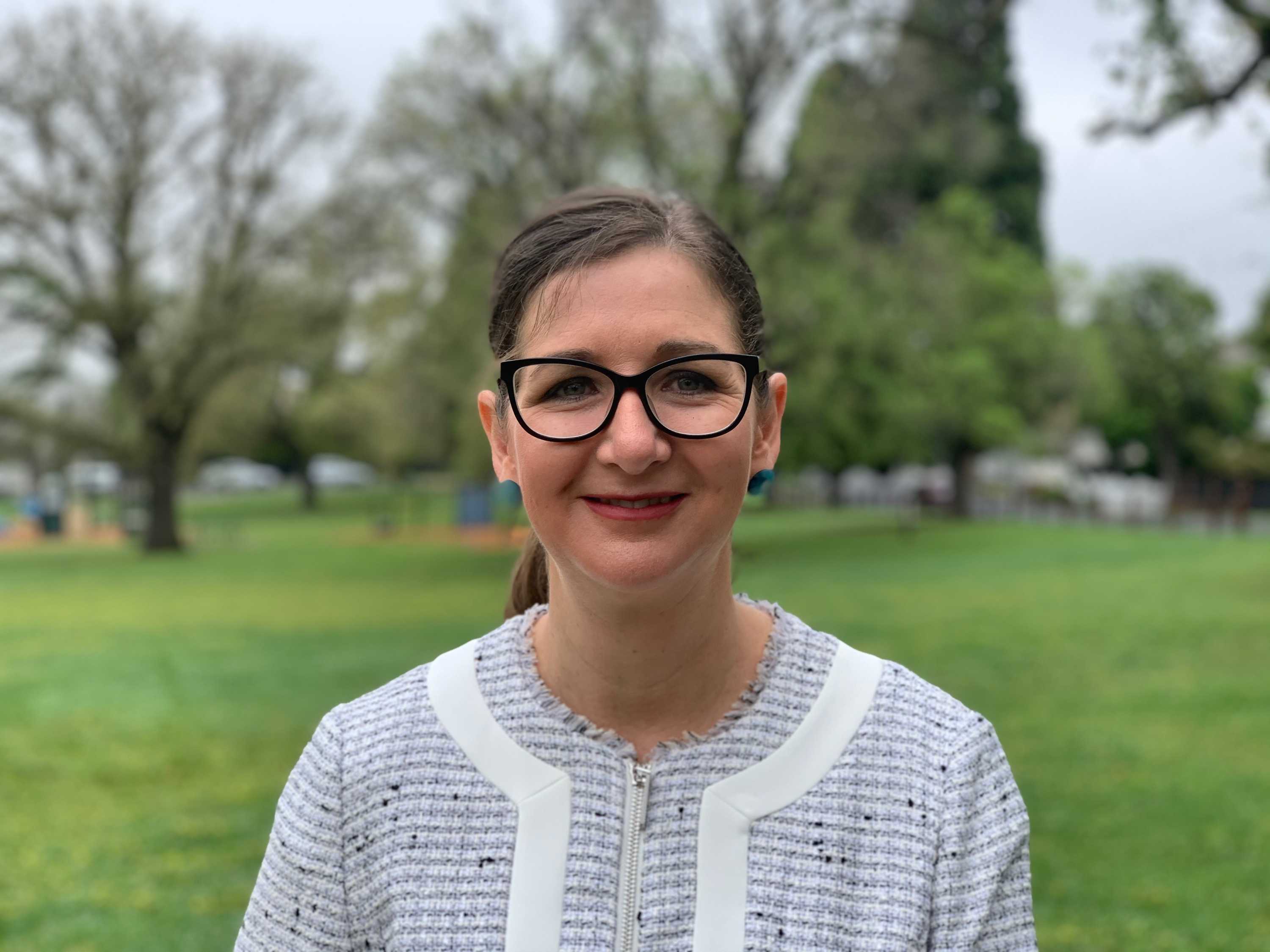 Clare Savage stands in a park.