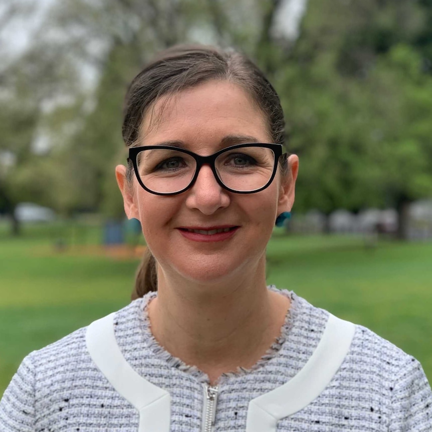 Clare Savage stands in a park.