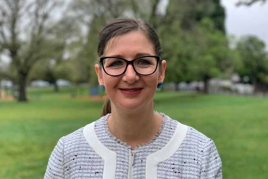 Clare Savage stands in a park.