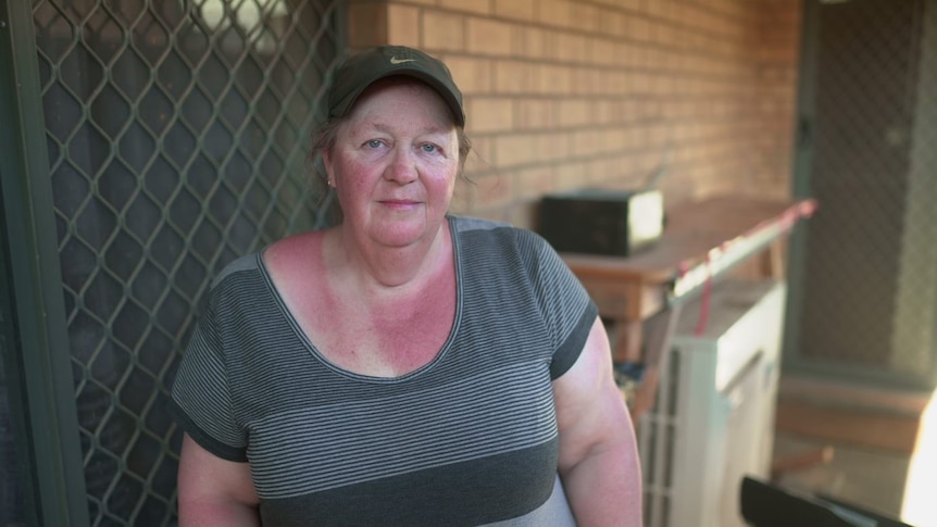 A woman standing outside a home