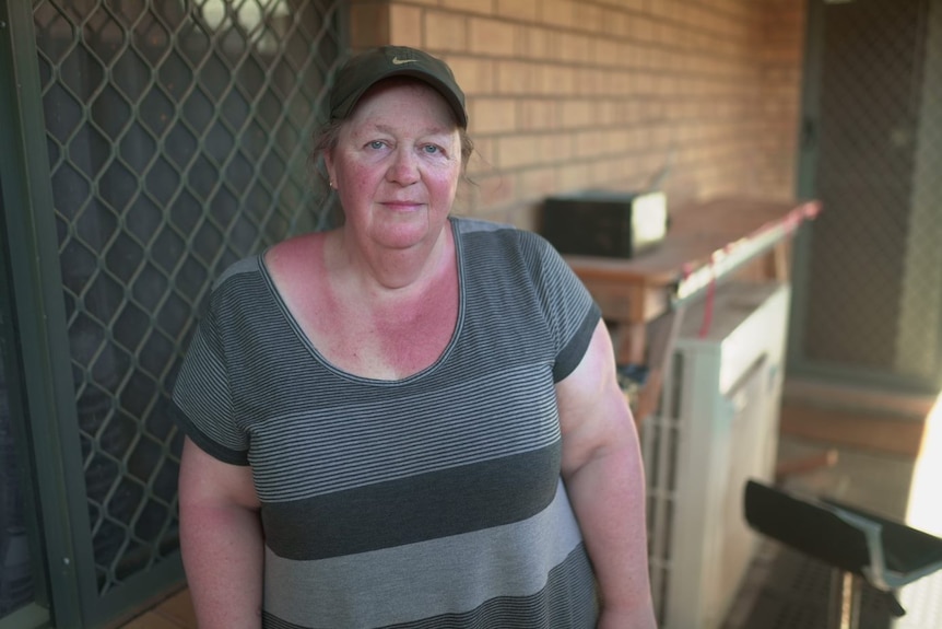 A woman standing outside a home