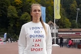 A woman wears a white jumper with 'I don't do doping' written on it while walking in public.