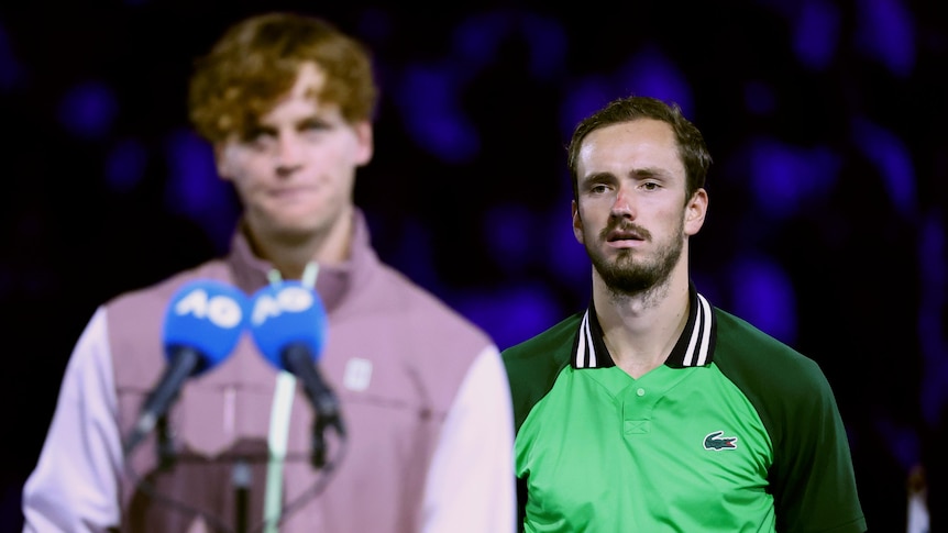 Daniil Medvedev looks miserable and ill as Jannik Sinner speaks in front of him after the Australian Open final.