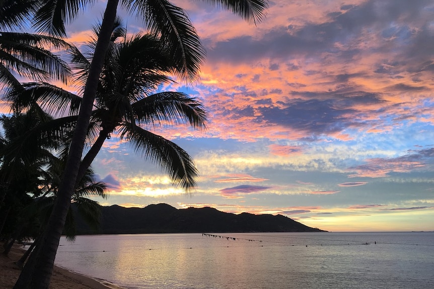 A blue, pink and purple sky over a silhouette of Magnetic Island