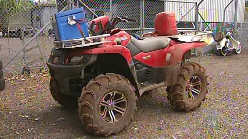 A red quad bike on a farm.