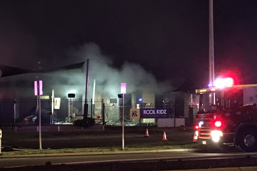 A fire truck is seen outside a childcare centre where smoke billows out after it caught on fire.
