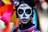 A woman dons dark black makeup and wears bright colourful laces