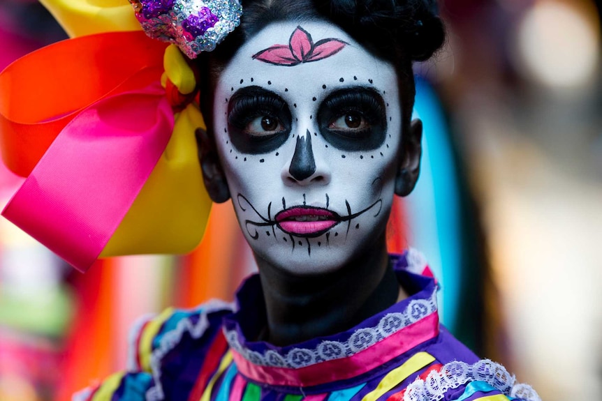 A woman dons dark black makeup and wears bright colourful laces