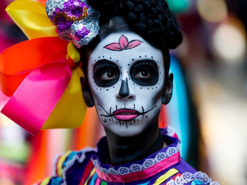 A woman dons dark black makeup and wears bright colourful laces