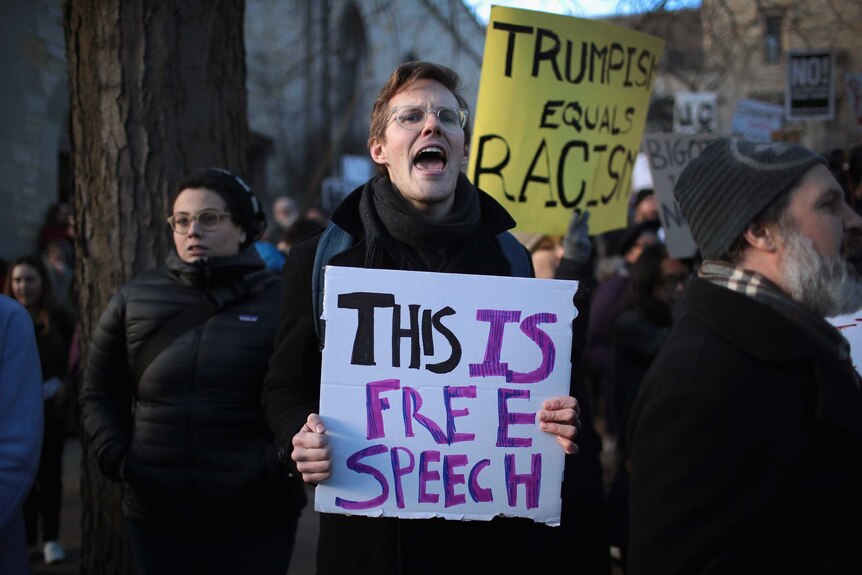 A man carries a sign saying "this is free speech" at a protest in Chicago.