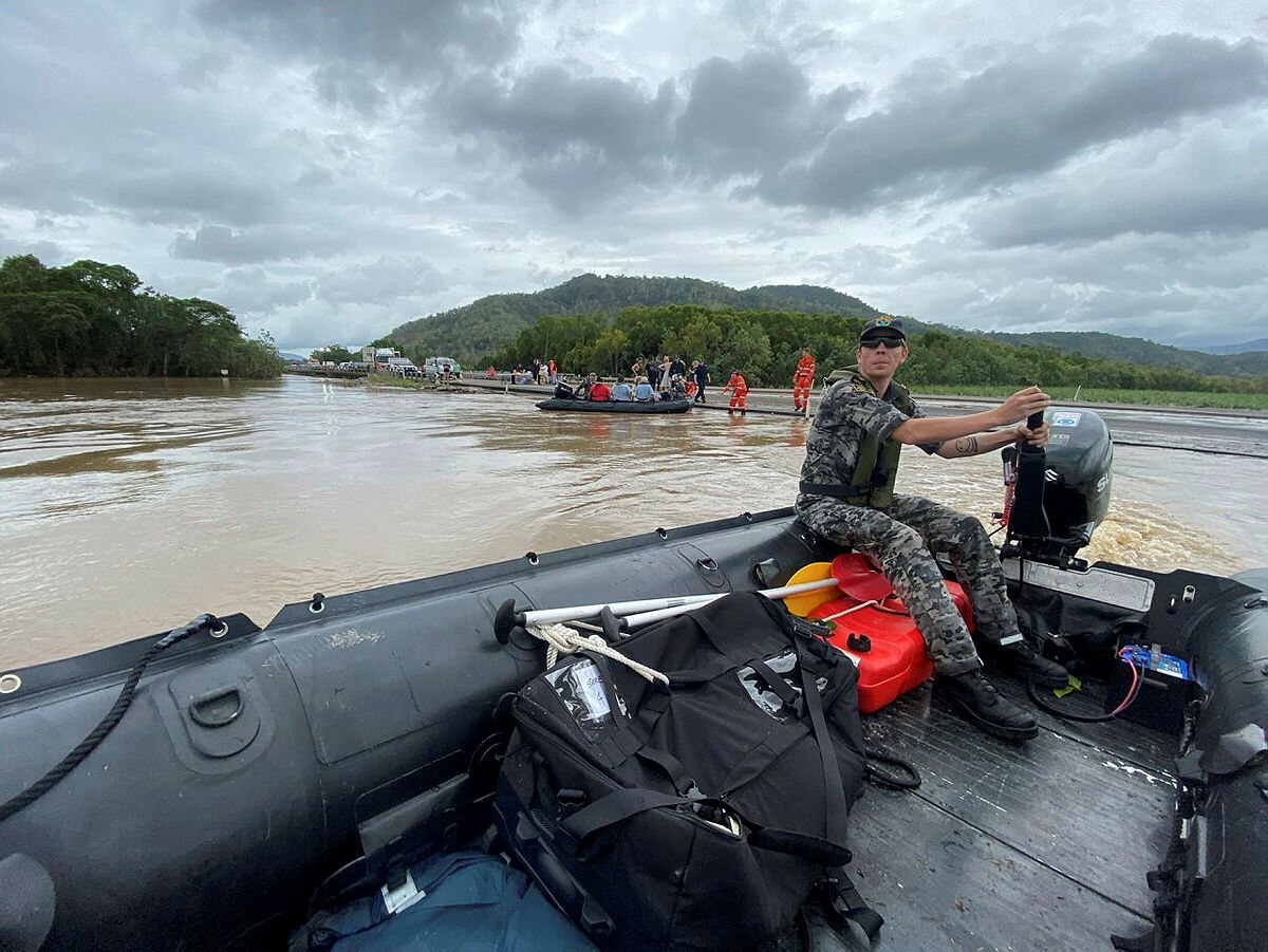 Navy personnel rescuing people from flooded homes in Cairns