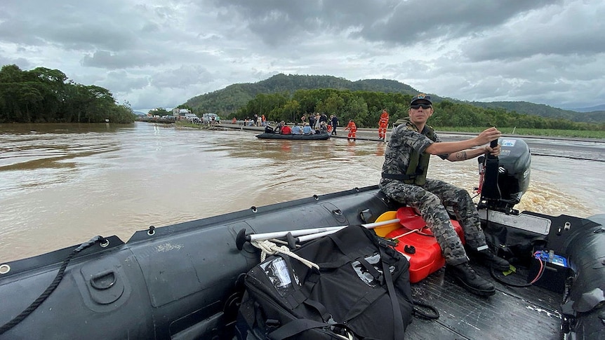 Navy personnel rescuing people from flooded homes in Cairns