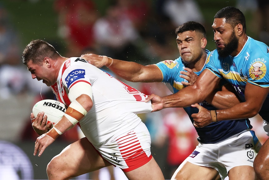 A man plunges over to score a try in a rugby league match