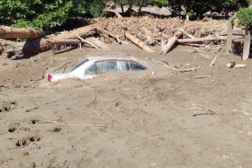 A car submerged in mud. 