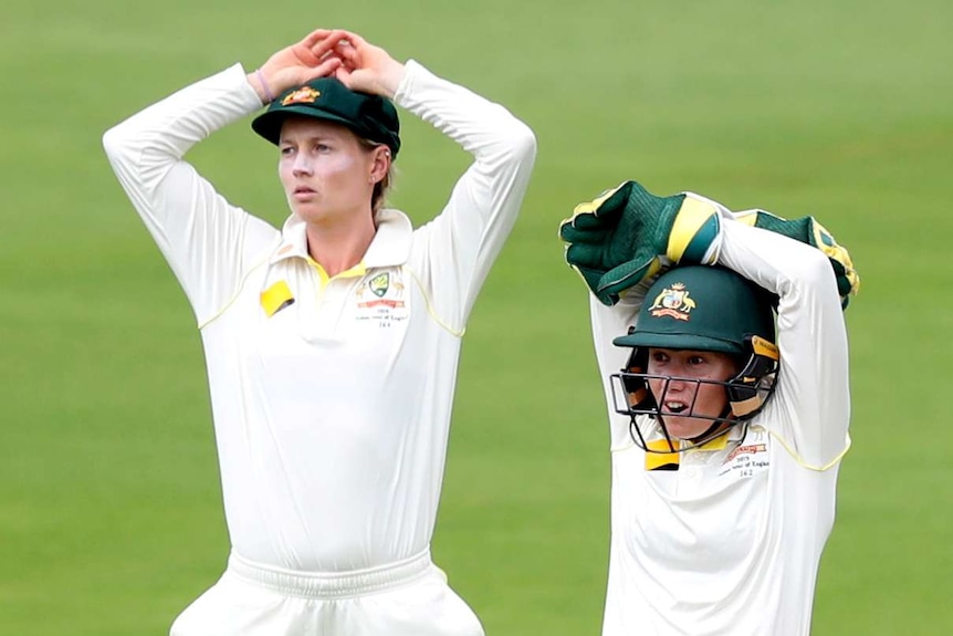 Australia's Meg Lanning (left) and Alyssa Healy (right) put their hands on their heads while fielding in the Women's Ashes Test.