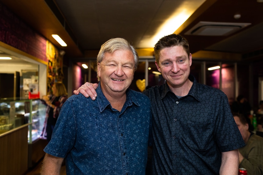 Two men embracing and smiling