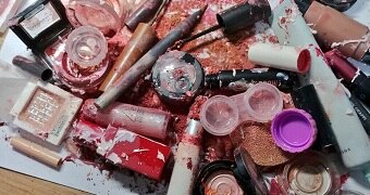 A table with a pile of smashed up makeup.
