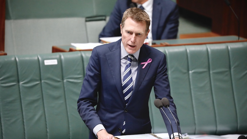 Christian Porter wearing a navy suit standing in Parliament mid-sentence